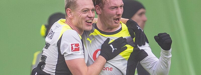 Julian Brandt (r) jubelt mit Julian Ryerson über seinen Treffer. - Foto: David Inderlied/dpa