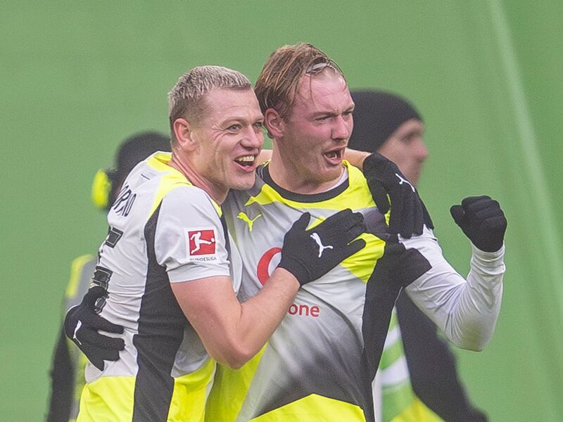 Julian Brandt (r) jubelt mit Julian Ryerson über seinen Treffer. - Foto: David Inderlied/dpa