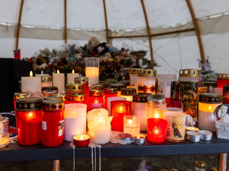 Menschen haben Kerzen und Blumen für die Opfer abgelegt. (Archivbild)  - Foto: Philipp von Ditfurth/dpa