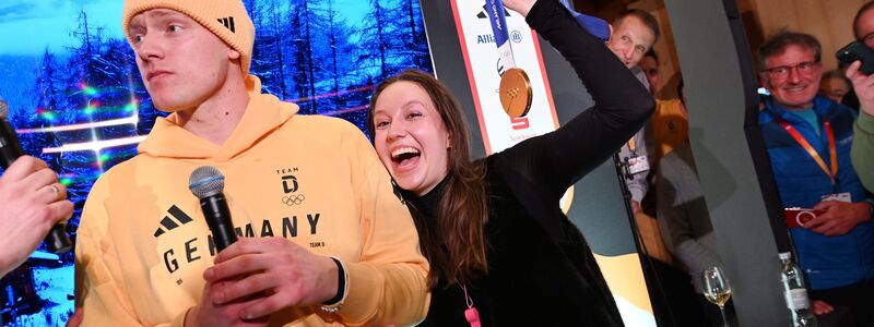 Rodler Max Langenhan steht mit seiner Freundin Susi auf der Bühne und singt das Thüringenlied mit seinen Fans. - Foto: Frank May/ picture alliance/Team D/dpa