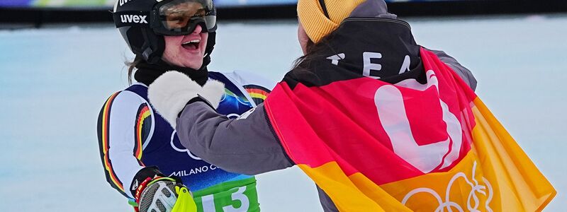 Emma Aicher (links) und Kira Weidle-Winkelmann jubeln über Olympia-Silber in der Team-Kombination. - Foto: Michael Kappeler/dpa