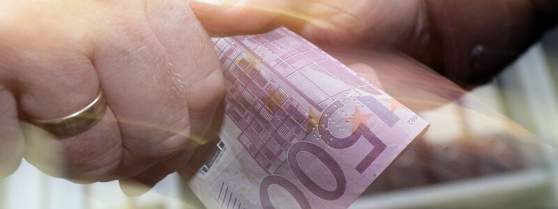 Ein 500-Euro-Schein wechselt den Besitzer (Illustration) - Foto: Peter Steffen/dpa