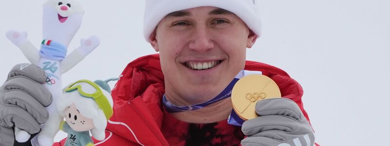 Franjo von Allmen zeigt eine seiner drei olympischen Goldmedaillen. - Foto: Rebecca Blackwell/AP/dpa