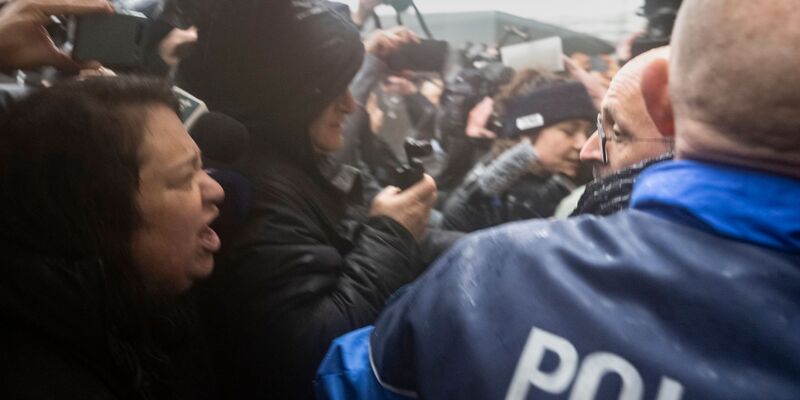 Angehörige von Opfern beschimpfen die Barbesitzer der als Mörder. - Foto: Alessandro Della Valle/KEYSTONE/dpa