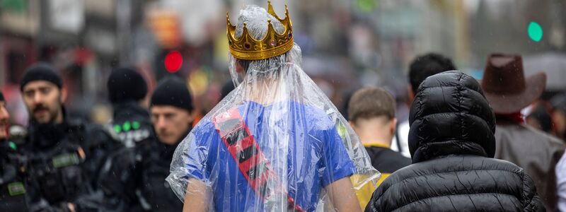 Regencape mit Krone: Die rheinischen Narren mussten an Weiberfastnacht tapfer sein. - Foto: Thomas Banneyer/dpa