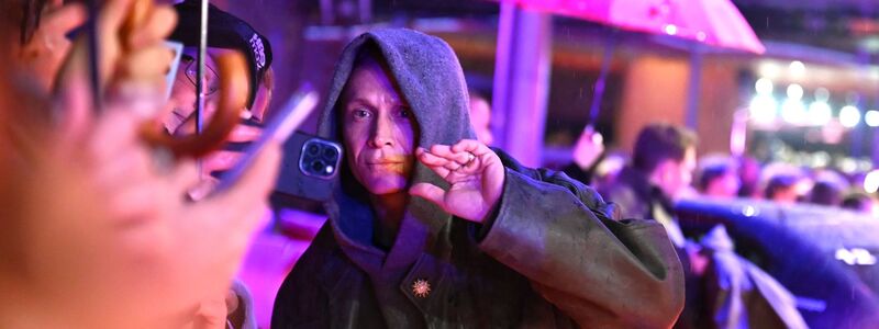 Matthias Schweighöfer auf dem roten Teppich - mit Fans und Regenschirmen. - Foto: Elisa Schu/dpa