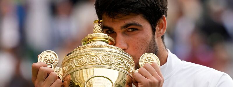 Liebkosung für den Pokal: Tennisprofi Carlos Alcaraz freute sich sichtlich über den Sieg im Wimbledon-Final 2023. (Archivbild) - Foto: Kirsty Wigglesworth/AP/dpa