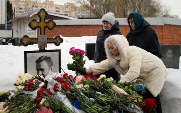 Angehörige des vor zwei Jahren im Straflager zu Tode gequälten Kremlgegners Alexej Nawalny haben am Grab des russischen Oppositionsführers Blumen niedergelegt. - Foto: Alexander Zemlianichenko/AP/dpa