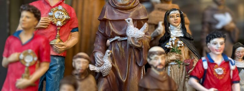 Figuren des alten und des neuen Heiligen stehen in Souvenirshops nebeneinander. (Archivbild) - Foto: Christoph Sator/dpa