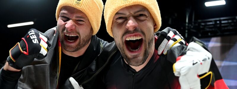 Johannes Lochner (l) und Georg Fleischhauer sind am Ziel: Gold im Zweierbob. - Foto: Robert Michael/dpa