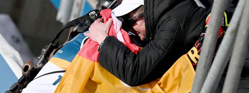 Philipp Horn wird im Ziel von seiner weinenden Ehefrau Antonia getröstet. - Foto: Hendrik Schmidt/dpa