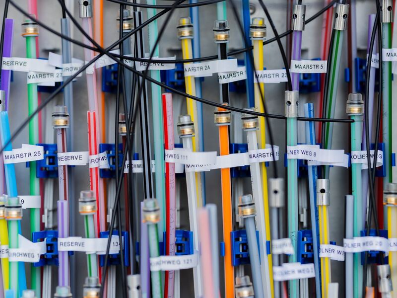 Glasfaserkabel in einem Verteilerkasten. - Foto: Rolf Vennenbernd/dpa