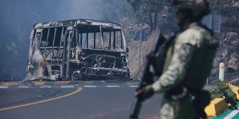 Ein Soldat steht in Mexiko - einem der drei Ausrichterländer der Fußball-WM im Sommer - neben einem ausgebrannten Bus. - Foto: Armando Solis/AP/dpa