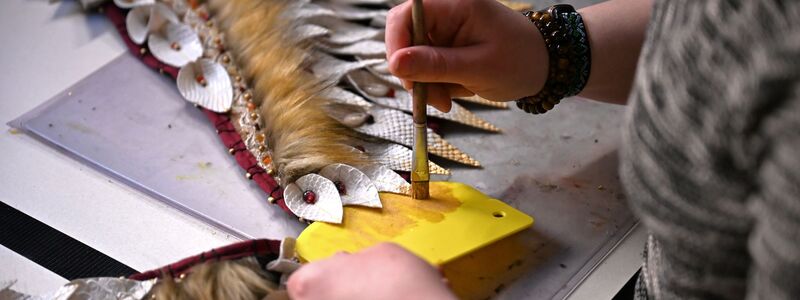 Mit Pinsel und goldener Farbe bemalt Toni ihr Kostüm.  - Foto: Jennifer Brückner/dpa