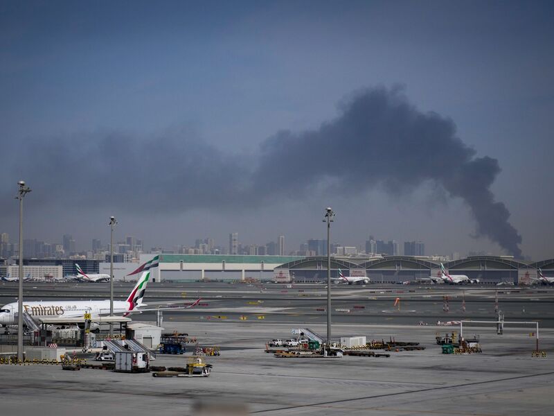 Nach einem iranischen Angriff ist am Flughafen von Dubai eine Rauchwolke zu sehen. - Foto: Altaf Qadri/AP/dpa