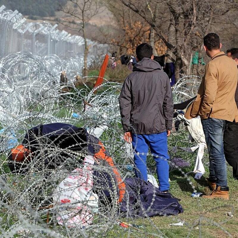 Flüchtlinge auf der Balkanroute vor einem Grenzzaun (Archiv) - Foto: via dts Nachrichtenagentur