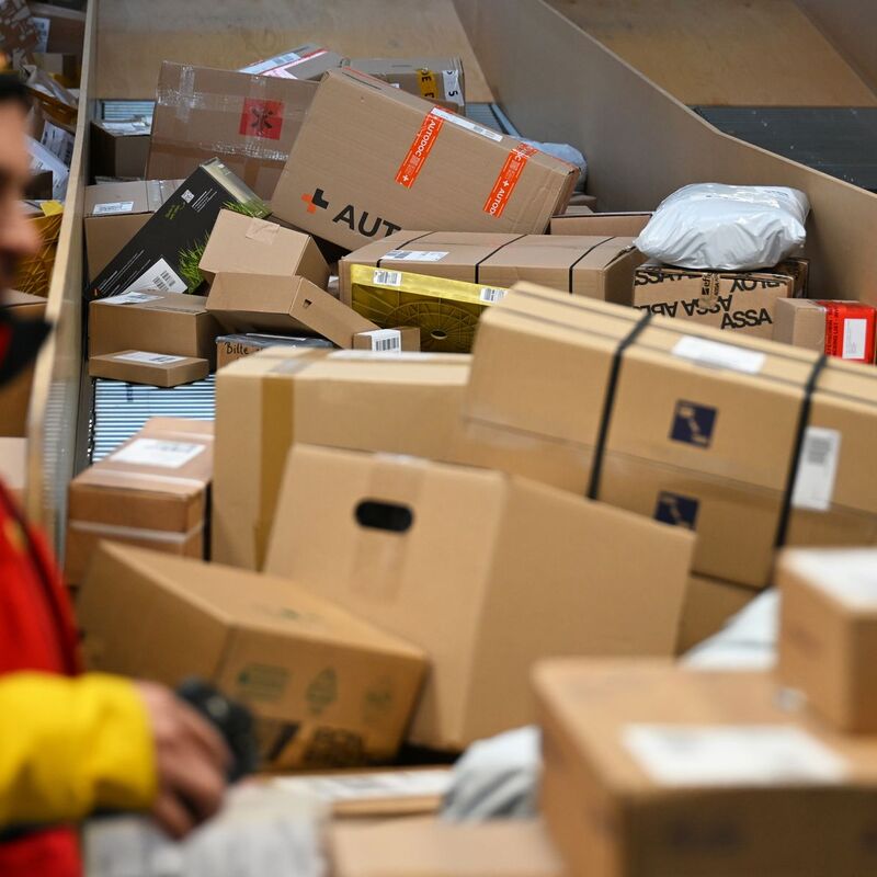 Ein DHL-Paketbote ist in einer Zustellbasis mit einer Vielzahl an Paketen beschäftigt. Der Logistikkonzern hat Jahreszahlen für 2025 vorgelegt, er hat profitablere Geschäfte gemacht als zuvor. - Foto: Wolf von Dewitz/dpa
