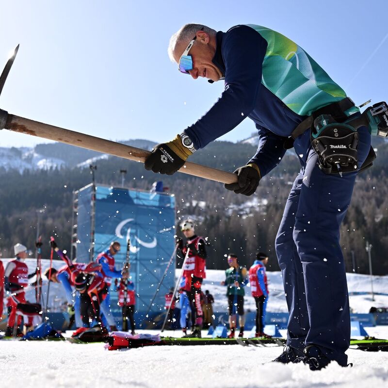 Ein Helfer präpariert die Strecke in Tesero.  - Foto: Martin Schutt/dpa