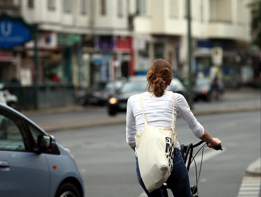 Junge Frau auf Fahrrad im StraÃŸenverkehr