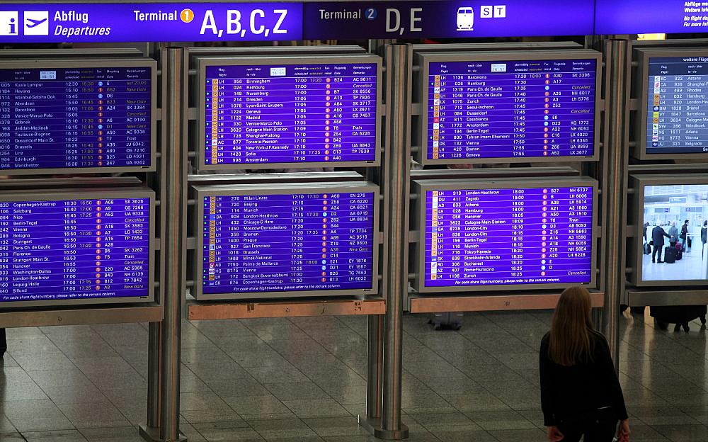 Frau vor Informationstafel am Frankfurter Flughafen