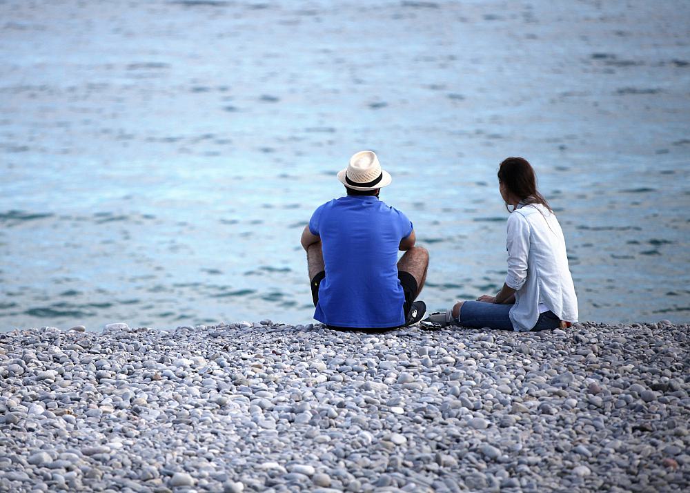 Mann und Frau sitzen am Strand