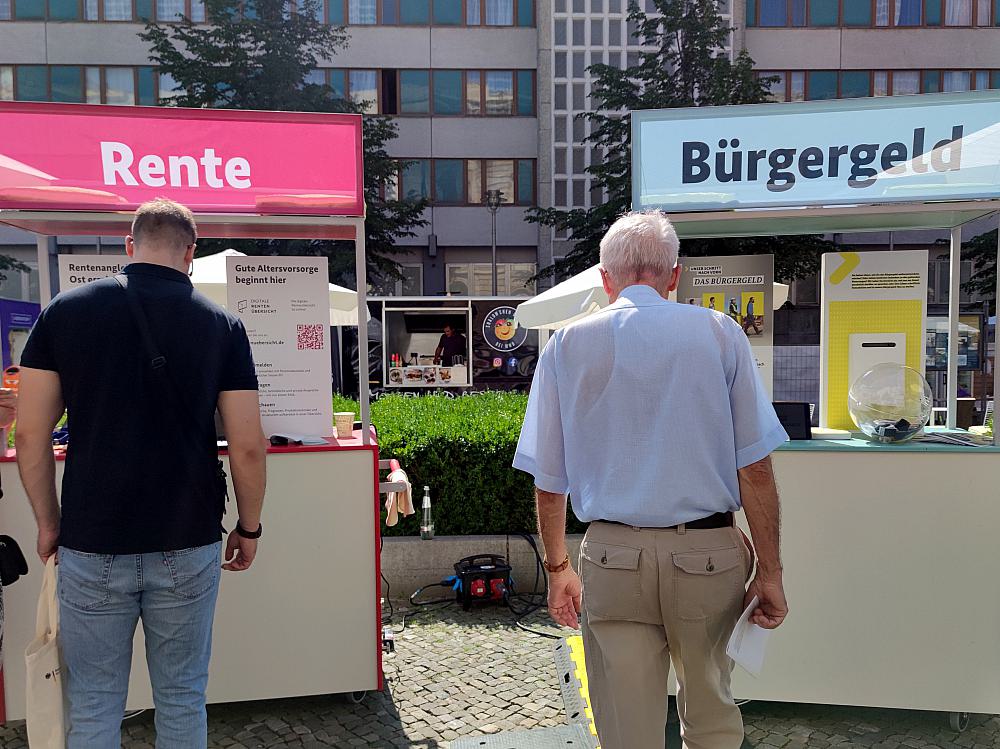 Passanten vor Infoständen zu Rente und Bürgergeld (Archiv)