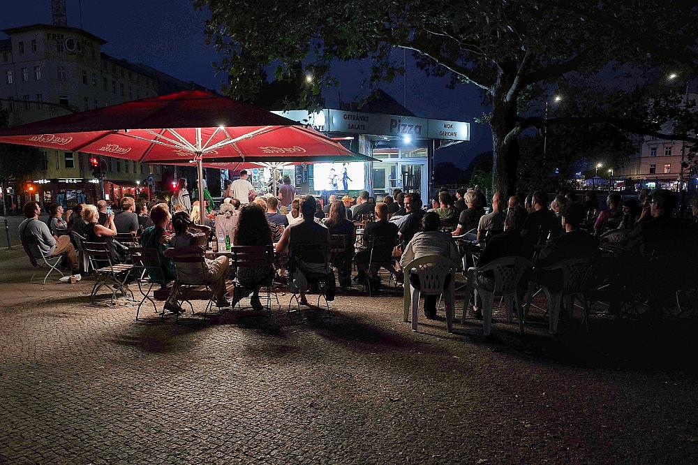 Interessierte schauen auf der Straße Fußball bei der WM 2026