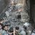 Männer und zwei Feuerwehrleute stehen nach einem israelischen Luftangriff vor Trümmern. Bei Angriffen des israelischen Militärs auf den Gazastreifen sind palästinensischen Angaben zufolge mehrere Menschen getötet worden. - Foto: Mohammed Talatene/dpa