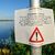 Ein Warnhinweis hängt bei Genschmar am Ufer der Oder. - Foto: Patrick Pleul/dpa