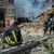 Ein Feuerwehrmann macht eine Verschnaufpause, während zwei seiner Kollegen vor einem zerstörten Gebäude der Chemisch-Mechanischen Hochschule in Slowjansk ein Feuer löschen. - Foto: Madeleine Kelly/SOPA Images via ZUMA Press Wire/dpa