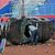 Ein Polizist in Zivil inspiziert ein Polizeiauto, das bei Fußballkrawallen im Kanjuruhan-Stadion in Malang zerstört wurde. - Foto: Trisnadi/AP/dpa