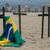 Eine brasilianische Fahne hängt an einem der Kreuze bei einer Gedenkveranstaltung für einen ungewöhnlichen Corona-Protest. Die Nichtregierungsorganisation Rio de Paz erinnert mit dieser Aktion an die Opfer. - Foto: Bruna Prado/AP/dpa