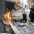 Eine Frau wärmt sich auf offener Straße in Kahramanmaras an einem Feuer auf. - Foto: Boris Roessler/dpa