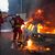 Feuerwehrleute löschen ein brennendes Auto am Rande der Ausschreitungen westlich von Paris. - Foto: Zakaria Abdelkafi/AFP/dpa