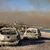 Ausgebrannte Autos am Strand von Kiotari. Im Hintergrund ist eine riesige Rauchwolke zu sehen. - Foto: Christoph Reichwein/dpa