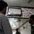 Menschen in einem Friseur-Salon verfolgen eine Nachrichtensendung, in der über eine riskante Rettungsmission an der Seilbahn berichtet wird. - Foto: K.M. Chaudary/AP/dpa