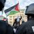 Ein Teilnehmer einer verbotenen Pro-Palästina-Demonstration in Frankfurt am Main schwenkt eine Palästina-Flagge, während Polizisten die Situation beobachten. - Foto: Hannes P. Albert/dpa