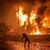 Ein Demonstrant wirft nach dem Angriff auf das Krankenhaus im Gazastreifen Steine auf ein brennendes Gebäude in der Nähe der US-Botschaft in Beirut. - Foto: Stringer/dpa