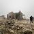 Syrer blicken auf eine verlassene medizinische Einrichtung, die nach Angaben der freiwilligen Rettungsorganisation White Helmets am späten Montagabend von iranischen Raketen getroffen wurde. - Foto: Omar Albam/AP/dpa