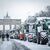 Zahlreiche schneebedeckte Traktoren stehen auf der Straße des 17. Juni vor dem Brandenburger Tor in Berlin. - Foto: Kay Nietfeld/dpa
