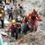 Rettungskräfte tragen ein Opfer aus dem von einem Erdrutsch betroffenen Dorf Masara. - Foto: Uncredited/AP/dpa