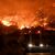 Flammen färben den Himmel glutrot. - Foto: Uncredited/AP