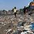 Menschen spazieren am Strand des Badhwar Park im indischen Mumbai an Plastikmüll vorbei. (Archivbild) - Foto: Rajanish Kakade/AP/dpa