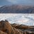 Zwei Studenten der New York University sitzen auf einem Felsen mit Blick auf den grönländischen Helheim-Gletscher.  - Foto: Felipe Dana/AP/dpa