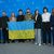 Das Team des Films «Strichka chasu» mit einer ukrainischen Flagge, auf der die Lehrerkollegen des Protagonisten und jetzigen Soldaten Borys Khovriak (M) unterschrieben haben.  - Foto: Soeren Stache/dpa